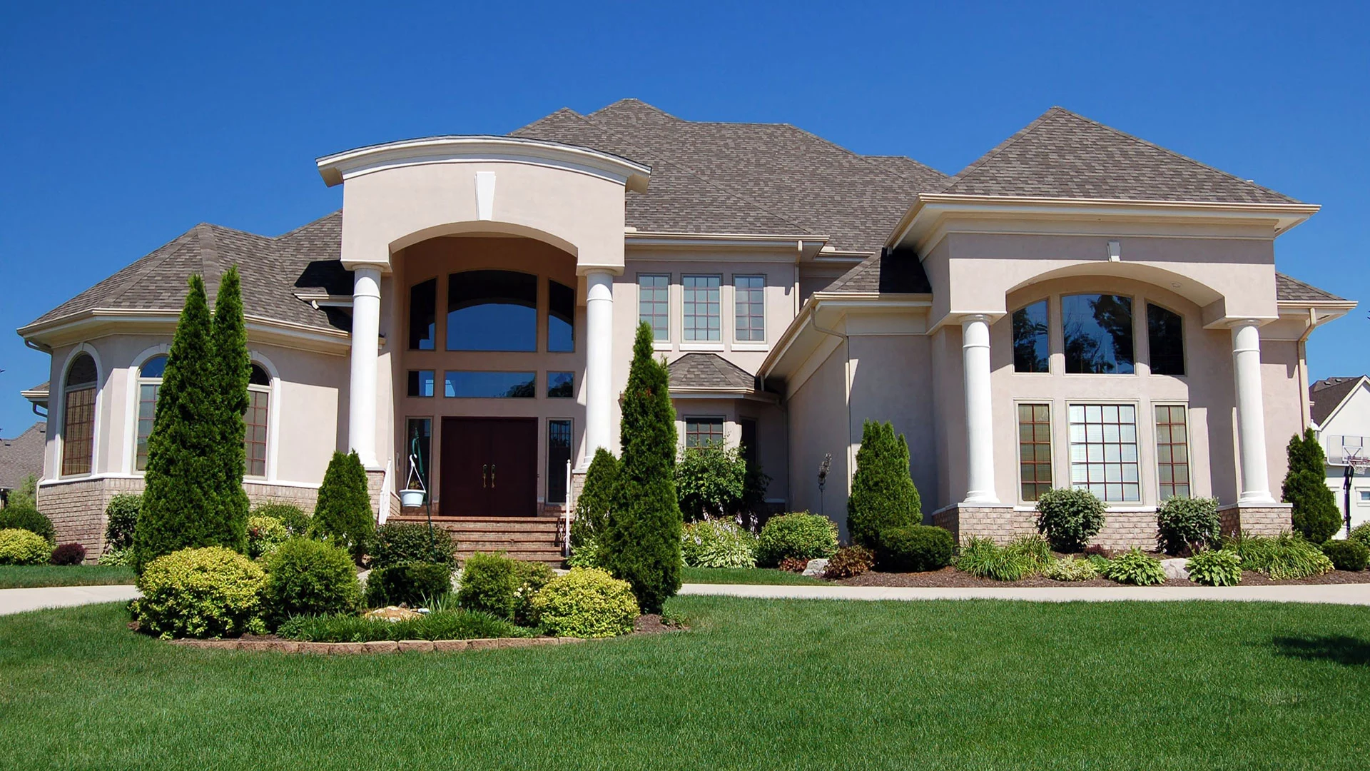 A white home with very well maintained trees and bushes in Council Bluffs, IA. 
