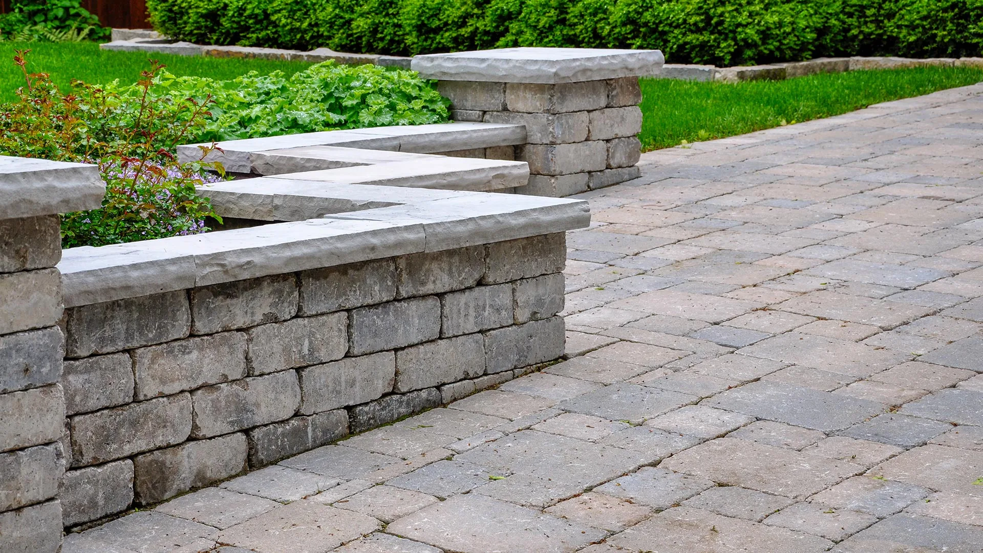 A zig zag stone retaining wall surrounding a patio behind a home in Fremont, NE. 