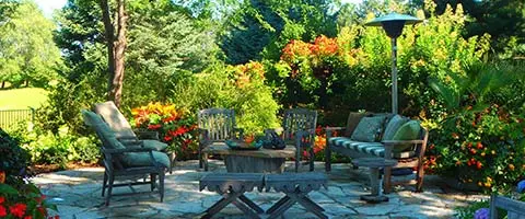 Patio with lush landscape plants and seating in Omaha, Nebraska.